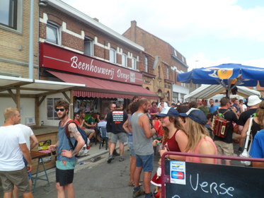 De beengouwerij op het Planciusplein gooit braadworsten op de bbq voor bij het biet van buurman café In de Zon.