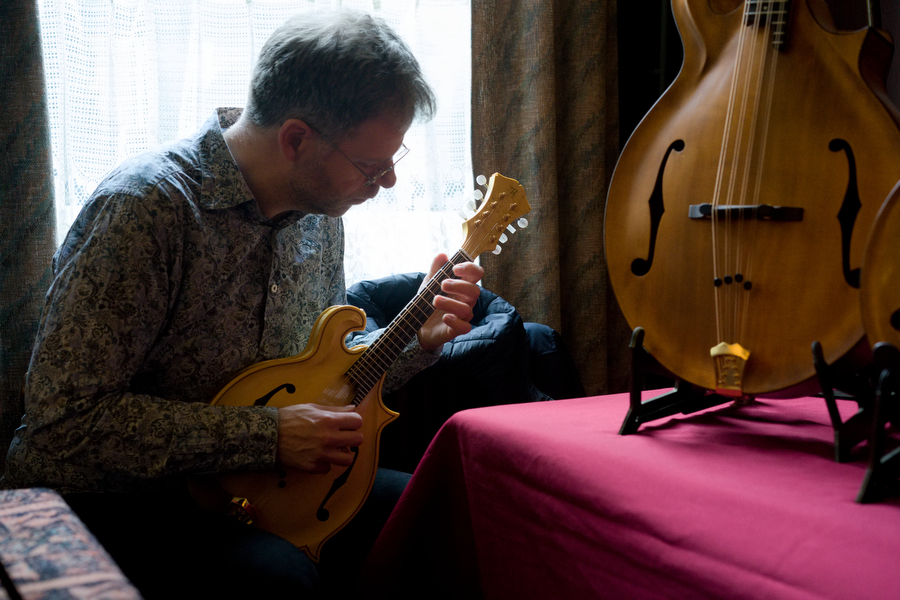 Janos Koolen probeert een mandoline van luthier Thijs van der Harst uit